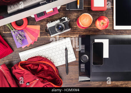 Overhead view of photo editing equipment; graphic tablet, digital tablet, retro camera, smartphone and desktop computer Stock Photo
