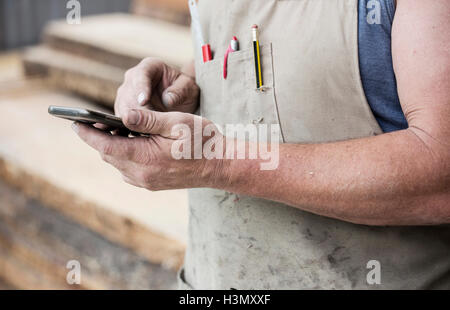 Carpenter using cellphone Stock Photo