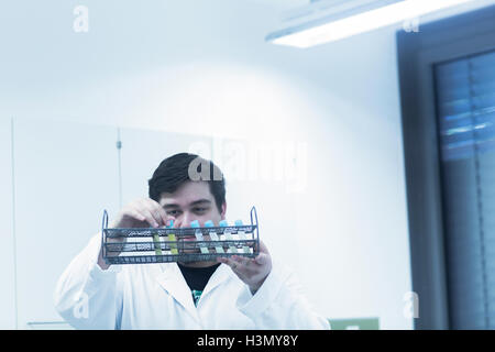 Scientist examining test tubes in rack Stock Photo