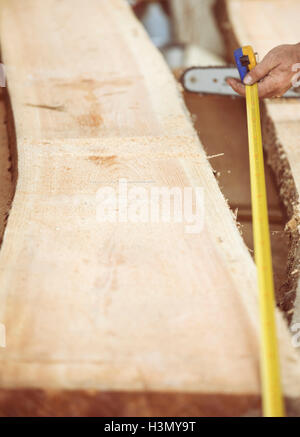Carpenter measuring wooden plank Stock Photo