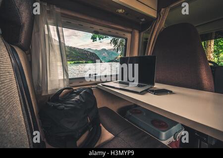 Work and Travel Concept. Laptop Computer on the Motorhome Table. Working While Traveling. Internet Connection While RVing. Stock Photo