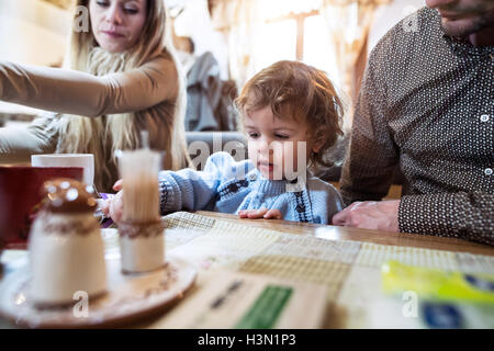 Young parents with son in restaurant waiting for meal. Stock Photo