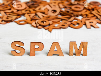 Word  Spam made with wooden letters on a background of other blurred letters Stock Photo