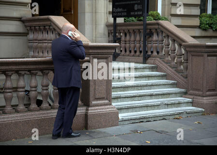 Glasgow street scenes businessman using mobile phone outside Victorian building steps Stock Photo