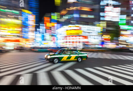 TOKYO - JUNE 11 2015: motion blurred taxi on pedestrian crossing Shibuya, Tokyo City, June 4, 2015 in Tokyo, Japan. Stock Photo