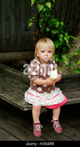 A little girl (2 yr old) eating an ice cream