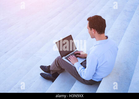 Young adult using laptop outdoors Stock Photo