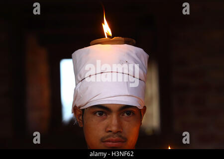 Bhaktapur, Nepal. 11th Oct, 2016. A devotee sits with lighted oil lamp on head while offering prayers during the Dashami, the tenth day of Hindu's biggest religious 'Dashain'' festival in Bhaktapur, Nepal © Sunil Sharma/ZUMA Wire/Alamy Live News Stock Photo