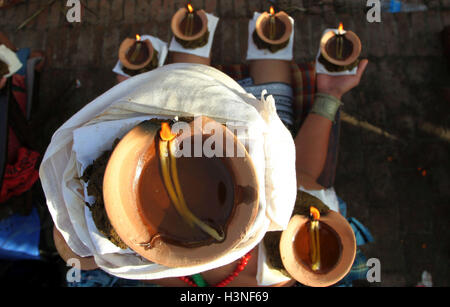 Bhaktapur, Nepal. 11th Oct, 2016. A devotee sits with lighted oil lamp on head and palms while offering prayers during the Dashami, the tenth day of Hindu's biggest religious 'Dashain'' festival in Bhaktapur, Nepal © Sunil Sharma/ZUMA Wire/Alamy Live News Stock Photo