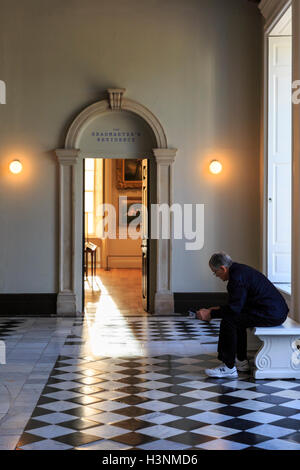 Royal Greenwich, London, 11th October 2016.  A visitor takes a rest in the restored Great Hall with its polished floors. The Queen's House, which was closed for restoration and refurbishment for over a year, re-opens to the public, marking the historic building's 400th anniversary. Credit:  Imageplotter News and Sports/Alamy Live News Stock Photo