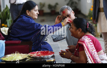 Kathmandu, Nepal. 11th Oct, 2016. Nepalese President Bidhya Devi Bhandari (L) offers Tika, coloured powder and rice used as a blessing, to a woman during the Dashain festival at the presidential residence in Kathmandu, Nepal, Oct. 11, 2016. Hindus in Nepal celebrate victory over evil during Dashain Festival by worshipping the Goddess Durga as well as other gods and goddesses. © Sunil Sharma/Xinhua/Alamy Live News Stock Photo