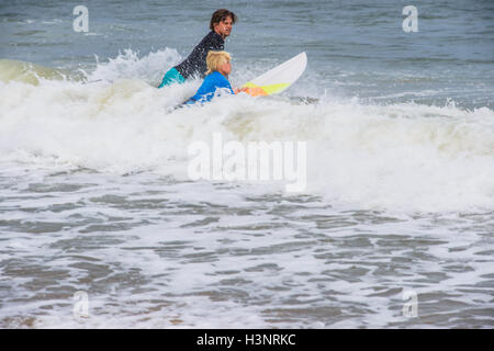 Father and son in sea with surfboards, getting ready to surf Stock Photo