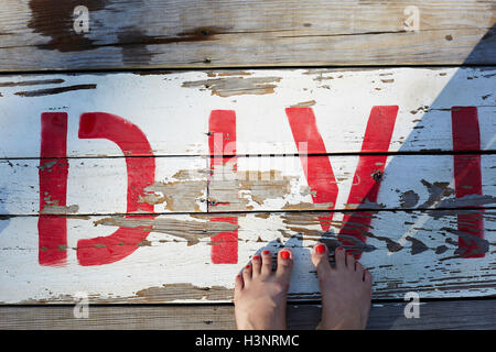 Woman's feet on wooden boards, overhead view Stock Photo