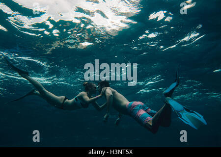 Underwater view of couple wearing flippers Stock Photo