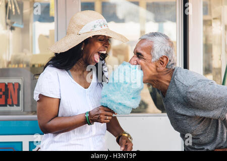 Senior couple eating cotton candy, laughing, Long Beach, California, USA Stock Photo