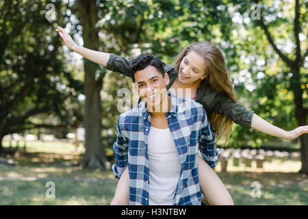 Man giving smiling woman piggyback Stock Photo
