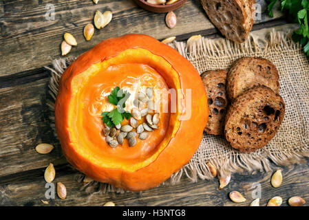 Pumpkin cream soup, seeds and toast bread, top view Stock Photo