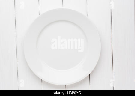 Empty plate on white wooden background. Top view with copy space Stock Photo