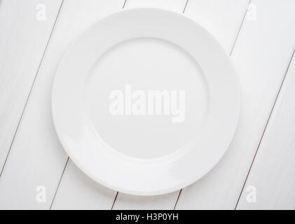 White table setting from above. Empty plate on planked wood . Stock Photo