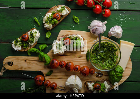 Grilled toasts with mozzarella, tomatoes and homemade pesto, vegetable on skewers Stock Photo