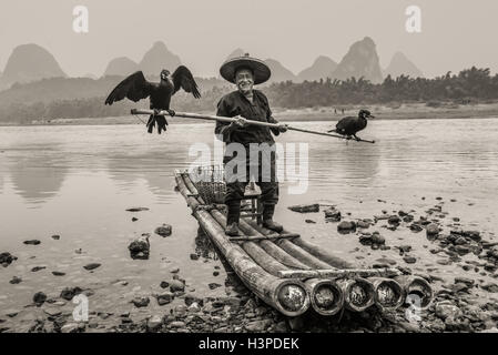 Cormorant fisherman with ancient bamboo boat on the Li River in Yangshuo, Guangxi, China Stock Photo