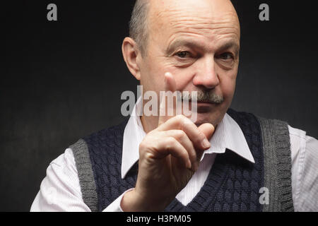 elderly man in a jacket and tie and looks strictly prohibits doing something Stock Photo