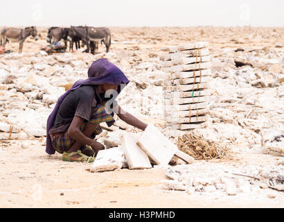 Afar man mining salt from salt flats in Afar region, Danakil Depression, Ethiopia. Stock Photo