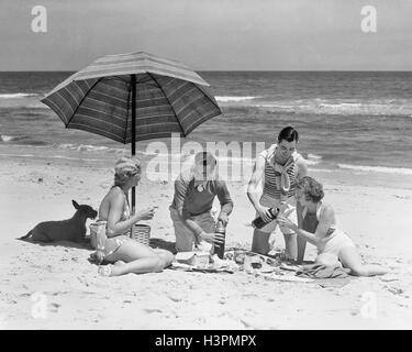 https://l450v.alamy.com/450v/h3pmpx/1930-1930s-two-couples-two-men-two-women-having-picnic-on-beach-by-h3pmpx.jpg