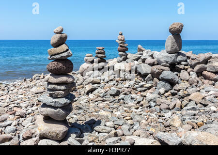 Piled beach pebbles at blue sea in Madeira Portugal Stock Photo