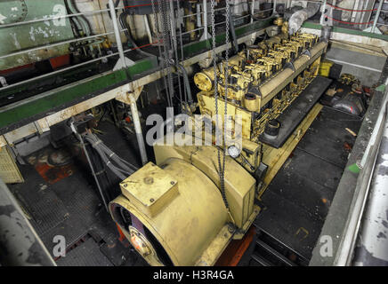 Yellow engine mounted on ship. Engine room on a old cargo boat ship. Stock Photo