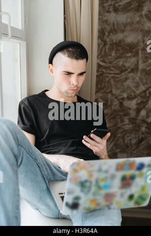 Man in black hat using laptop Stock Photo
