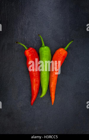 Two red and one green carrots on a gray slate Stock Photo