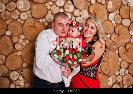 Father and mother with baby daughter posed at studio room Stock Photo