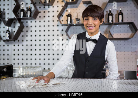 Smiling waitress cleaning bar counter Stock Photo
