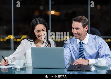 Businessman discussing with colleague over laptop Stock Photo