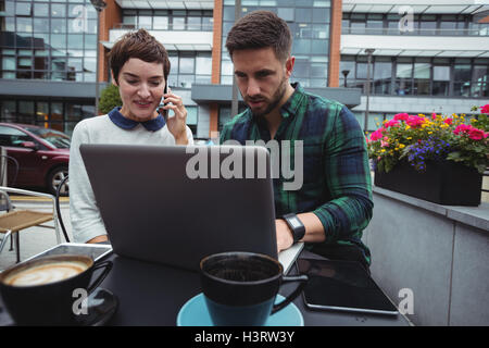 Business colleagues working while having coffee in cafeteria Stock Photo