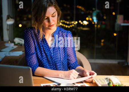 Businesswoman reading document at her desk Stock Photo
