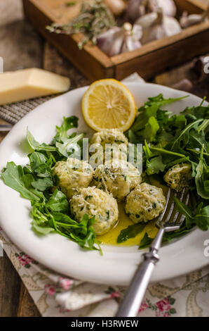 Ricotta dumplings with spinach, arugula salad and light dressing of lemon and olive oil. Topped with fresh parmesan cheese Stock Photo