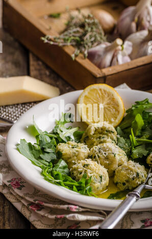 Ricotta dumplings with spinach, arugula salad and light dressing of lemon and olive oil. Topped with fresh parmesan cheese Stock Photo