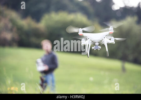 Unrecognizable man with flying drone. Sunny green nature. Stock Photo