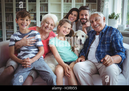Portrait of happy multi-generation family sitting on sofa in living room Stock Photo