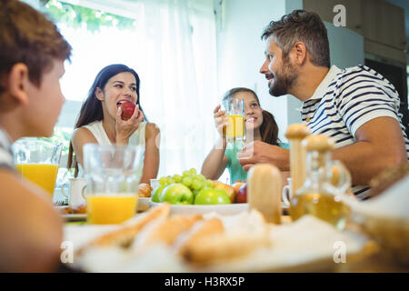 Happy family talking to each other while having breakfast together Stock Photo