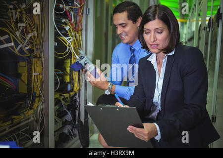 Technicians analyzing rack mounted server Stock Photo
