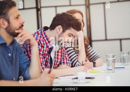 Colleagues sitting at desk in creative office Stock Photo