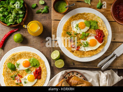 Huevos divorciados, delicious food with eggs, fresh salad and herbs and spicy and herby sauce Stock Photo