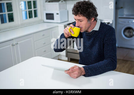 Man using digital tablet while having coffee Stock Photo