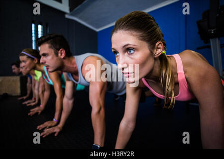 Athletes doing push-ups in gym Stock Photo