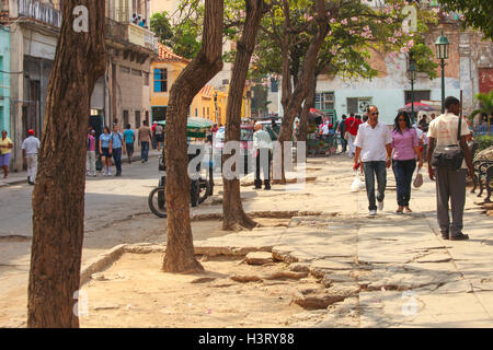 People walking in a street with holes in it in the center of Havana, Cuba Stock Photo