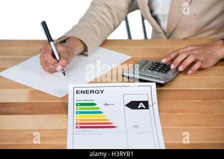 Businesswoman using calculator to calculate finance Stock Photo