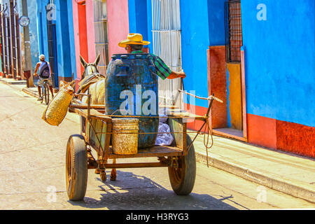 Senior man in Trinidad, Cuba driving his cart with containers Stock Photo
